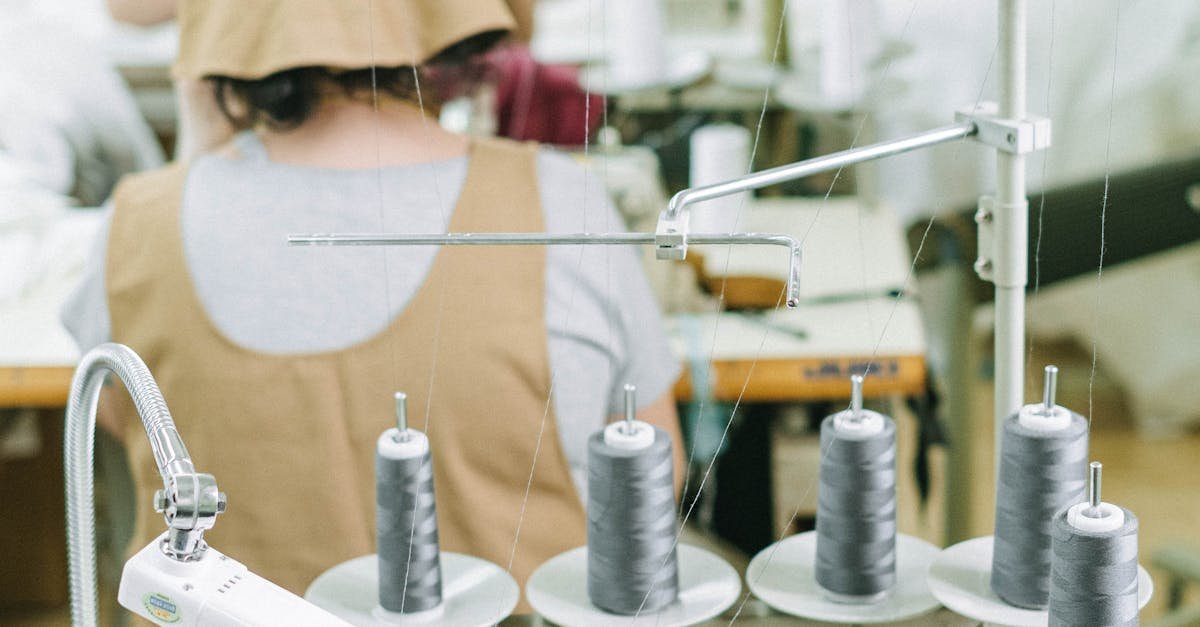 Sewing machines and workers in a textile factory, highlighting industrial manufacturing processes.
